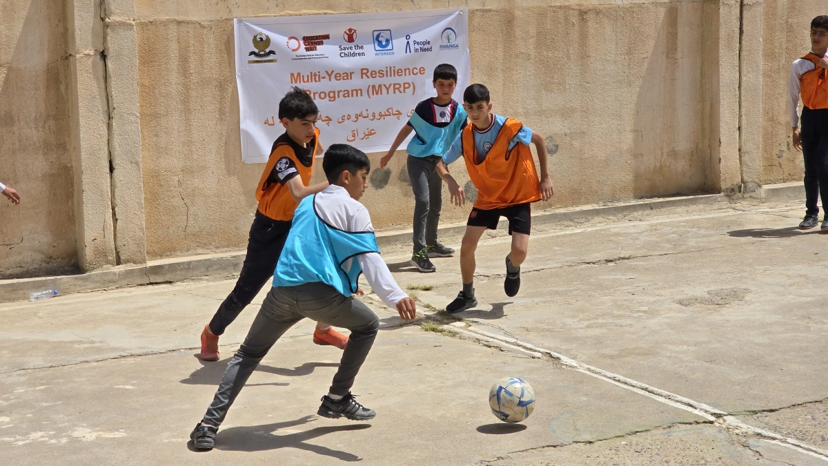 Students playing football on the new football court in the school