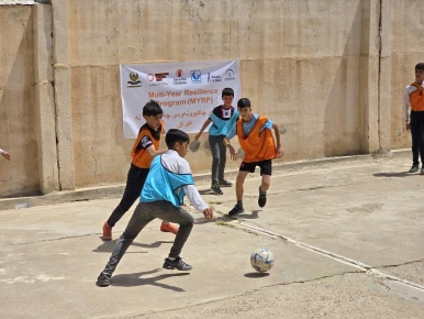 Students playing football on the new football court in the school