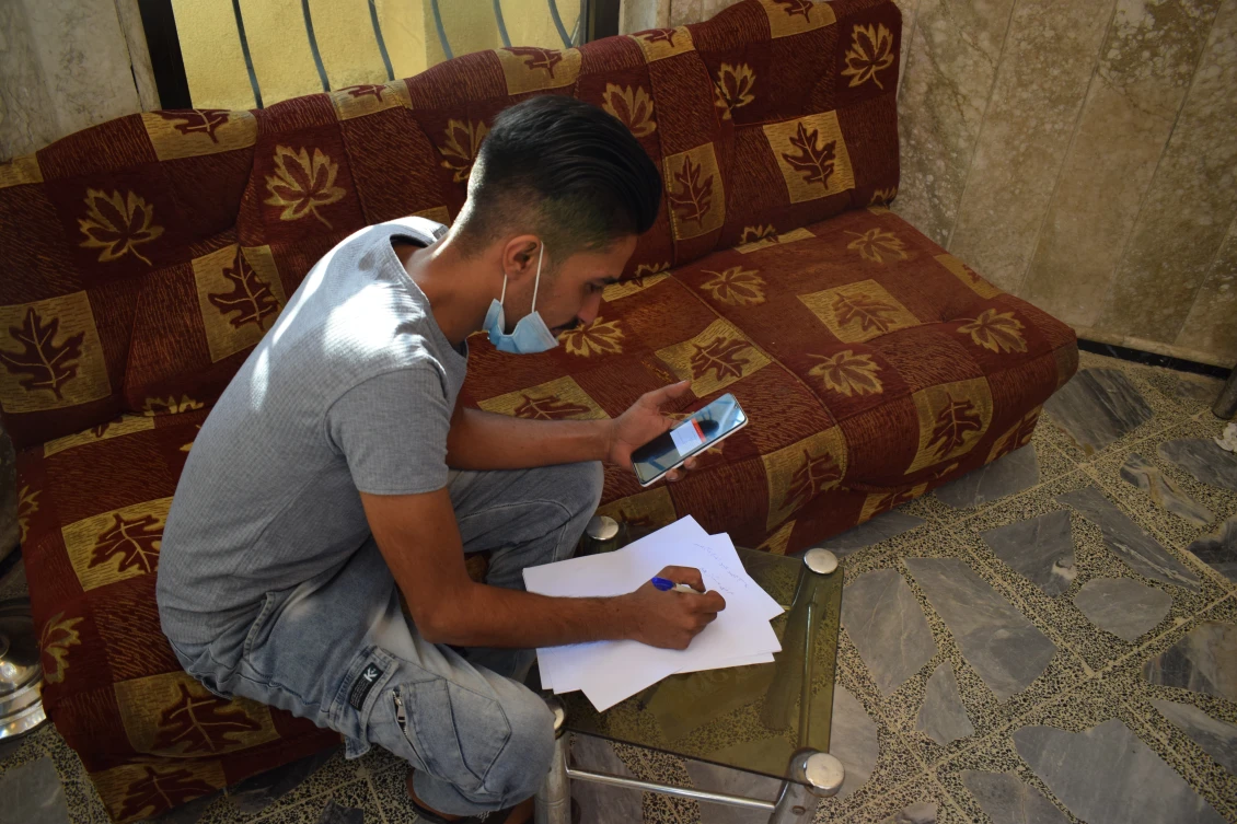 Muhammad taking part in a virtual business training session in the garden of his home in Mosul