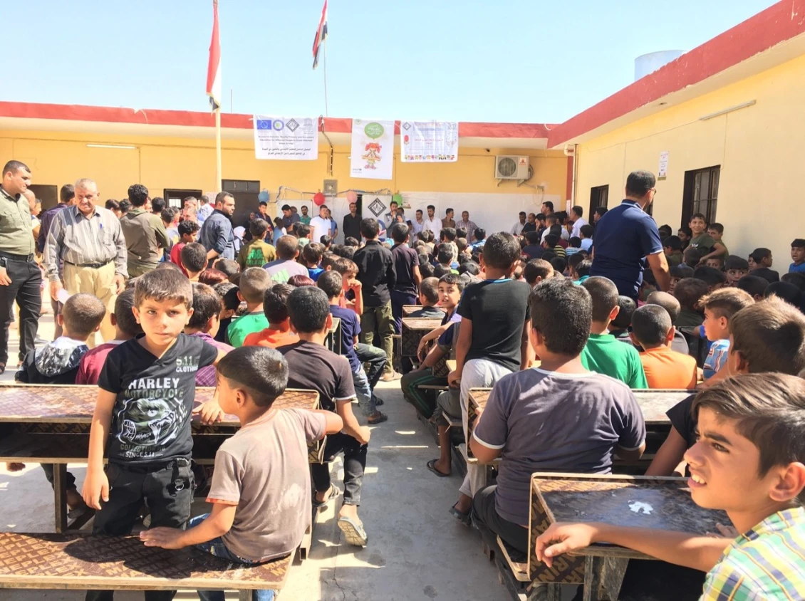 Children, parents and community leaders gather at the school