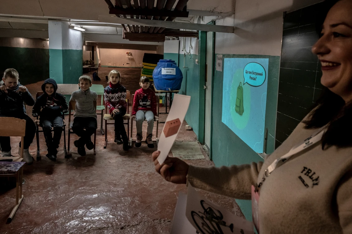 During the alarm alert, the children went down to the shelter. The teacher tells the pupils how to pack a “grab bag”.