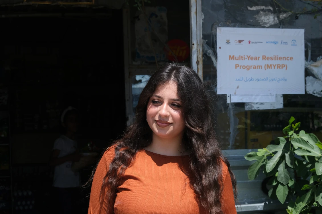 Rodan, 19, standing in front of the shop she works at in Basirma Camp, Kurdistan Iraq. Photo