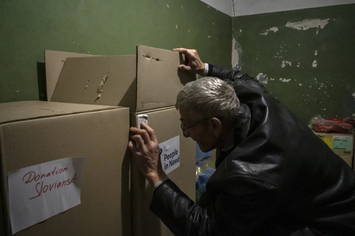 An employee inspects boxes of humanitarian aid. 