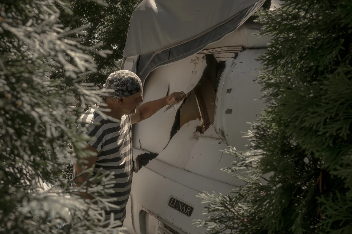 Alexander inspects a damaged mobile home 