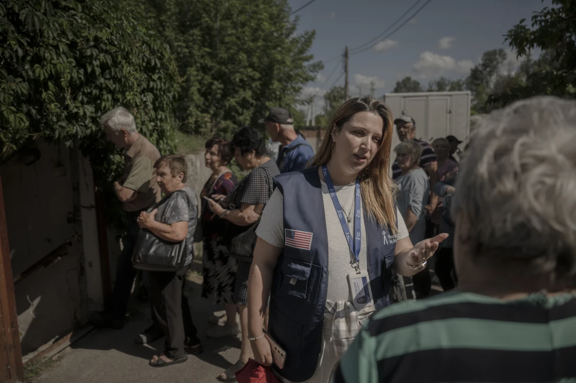 Anastasiia talks with people registering for assistance