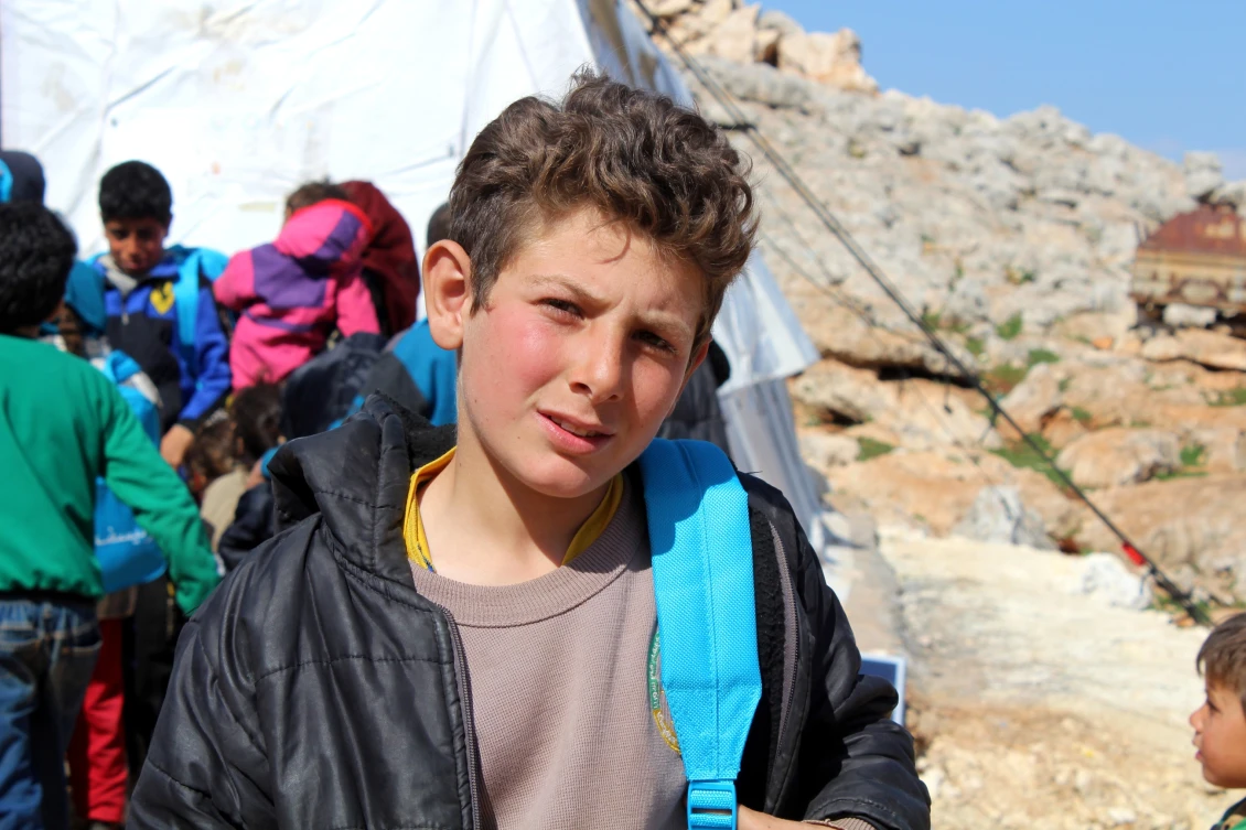 11-year-old Hasan with the new student kit he received as part of his placement test. 