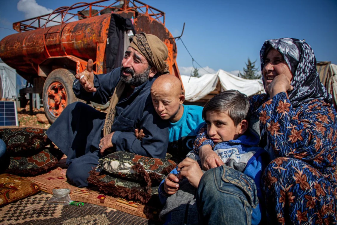 Khairo, his wife, and two of their children outside their tent
